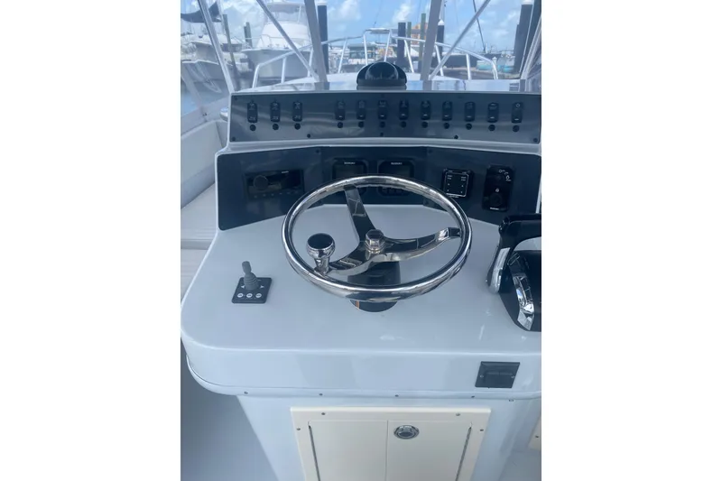 Slide: The Image of Boat control panel with steering wheel, switches, and throttle on a Salt Shaker 300, 1990 model. - 6
