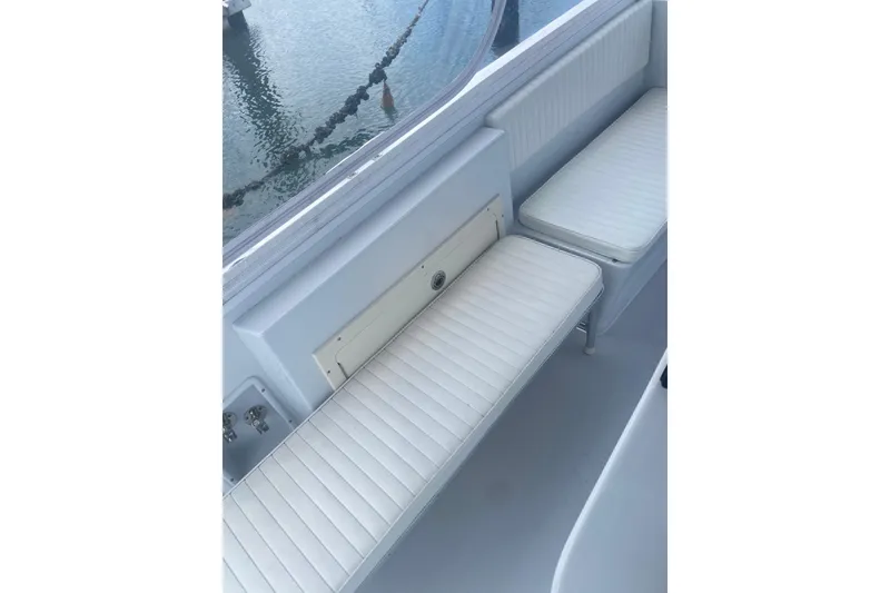 Slide: The Image of White cushioned seating on a Salt Shaker 300 boat, 1990 model, near water. - 7