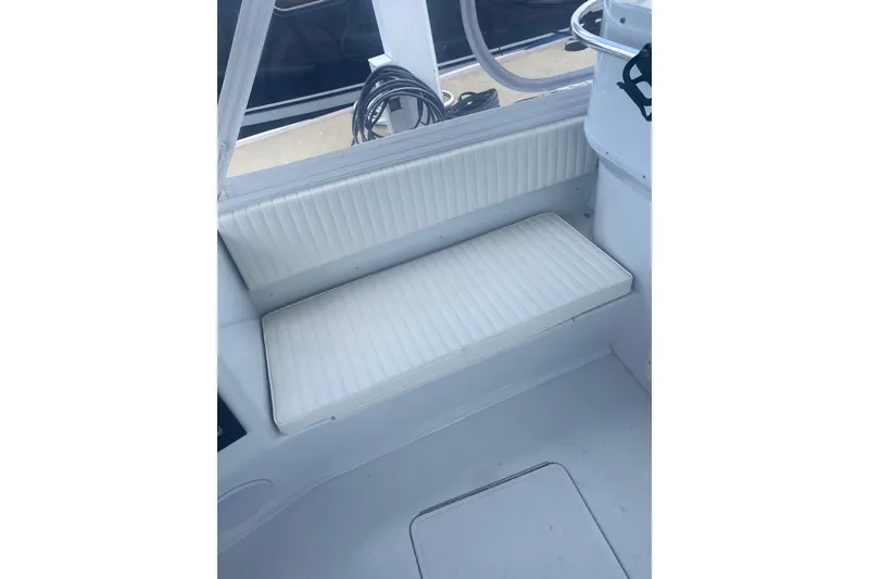 Slide: The Image of White cushioned bench seat on a 1990 Salt Shaker 300 boat interior. - 8