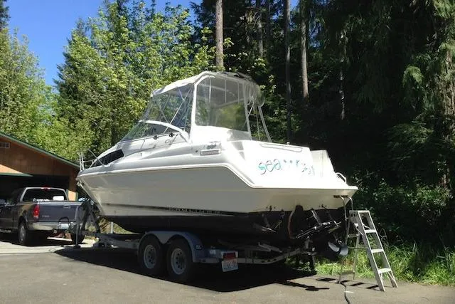 Slide: The Image of 1998 Bayliner 2655 Ciera Sunbridge boat on trailer in wooded area. - 1