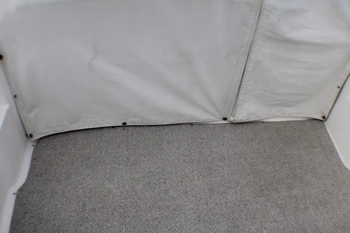 Slide: The Image of 1998 Bayliner 2655 Ciera Sunbridge interior with gray carpet and white canvas cover. - 19