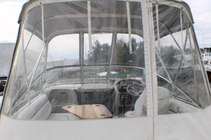 Slide: The Image of 1998 Bayliner 2655 Ciera Sunbridge cockpit with clear enclosure and steering wheel. - 25