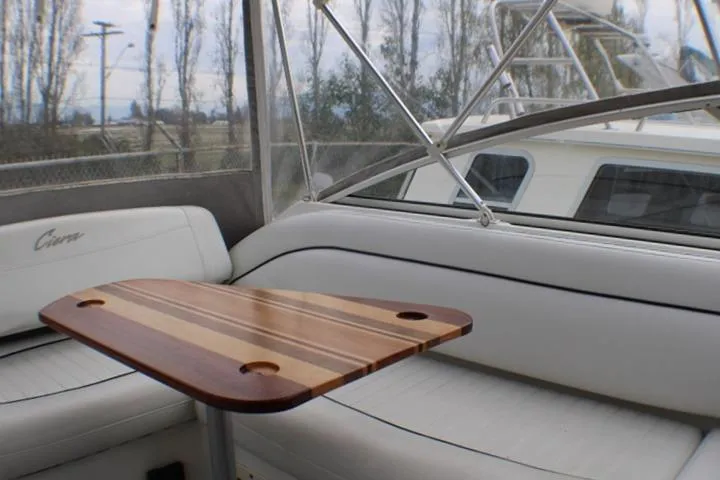 Slide: The Image of 1998 Bayliner 2655 Ciera Sunbridge interior with wooden table and cushioned seating. - 28