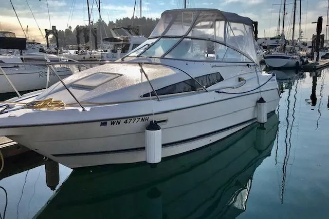 Slide: The Image of 1998 Bayliner 2655 Ciera Sunbridge docked in a marina, surrounded by other boats. - 3