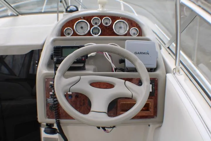 Slide: The Image of 1998 Bayliner 2655 Ciera Sunbridge helm with steering wheel and Garmin navigation system. - 32