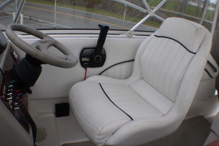Slide: The Image of 1998 Bayliner 2655 Ciera Sunbridge cockpit with white captain's chair and steering wheel. - 34