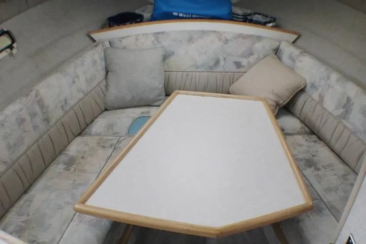 Slide: The Image of Interior of 1998 Bayliner 2655 Ciera Sunbridge with cushioned seating and table. - 39