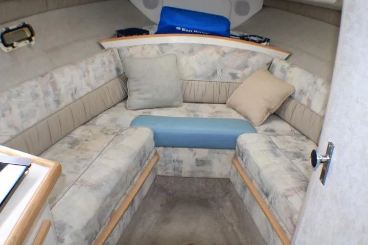 Slide: The Image of 1998 Bayliner 2655 Ciera Sunbridge cabin interior with cushioned seating and pillows. - 40
