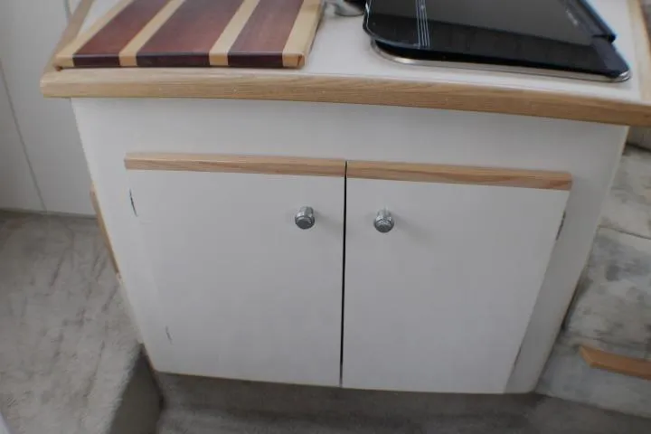 Slide: The Image of Interior view of a 1998 Bayliner 2655 Ciera Sunbridge, featuring a compact kitchen cabinet. - 48