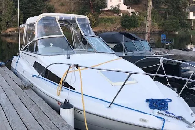 Slide: The Image of 1998 Bayliner 2655 Ciera Sunbridge docked at a marina, featuring a sleek white design. - 5