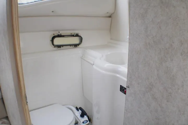 Slide: The Image of 1998 Bayliner 2655 Ciera Sunbridge bathroom with compact toilet and sink. - 55