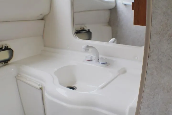 Slide: The Image of Interior of 1998 Bayliner 2655 Ciera Sunbridge boat, featuring a compact bathroom sink. - 56