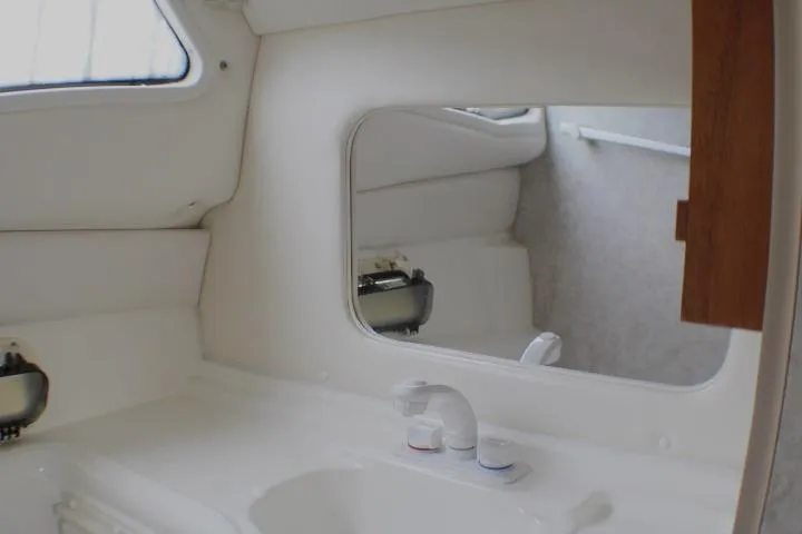 Slide: The Image of Interior of 1998 Bayliner 2655 Ciera Sunbridge boat bathroom with sink and mirror. - 57