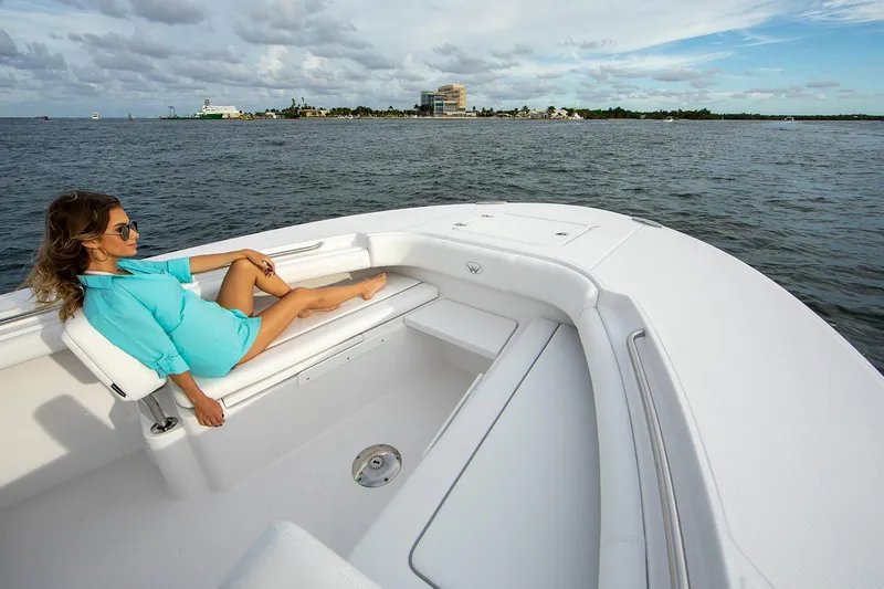 Slide: The Image of Manufacturer Provided Image: Woman relaxing on a 2025 Southport 30 FE boat, enjoying a scenic ocean view. - 11
