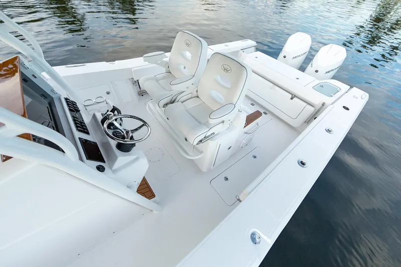 Slide: The Image of Manufacturer Provided Image: 2025 Southport 30 FE boat interior with dual seats and steering console on calm water. - 7