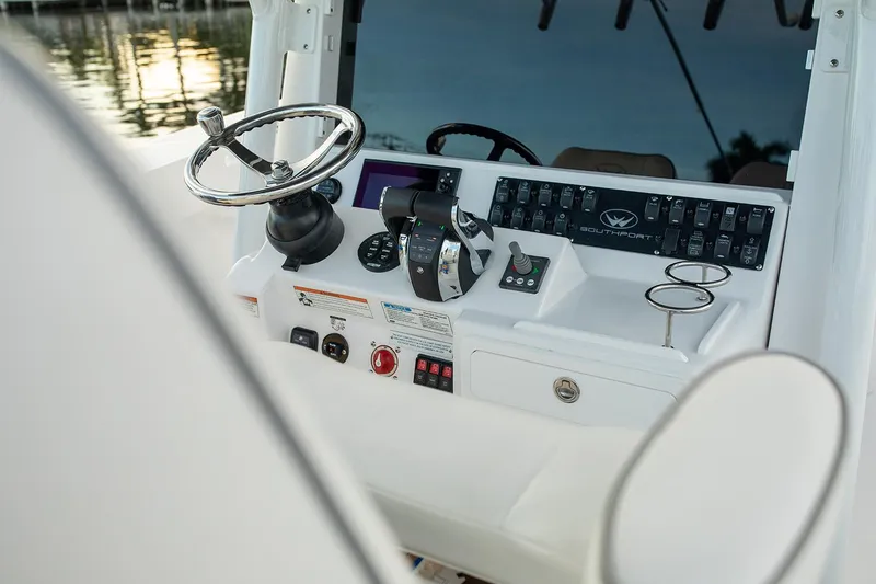 Slide: The Image of Manufacturer Provided Image: 2025 Southport 30 FE boat dashboard with steering wheel and control panel. - 9