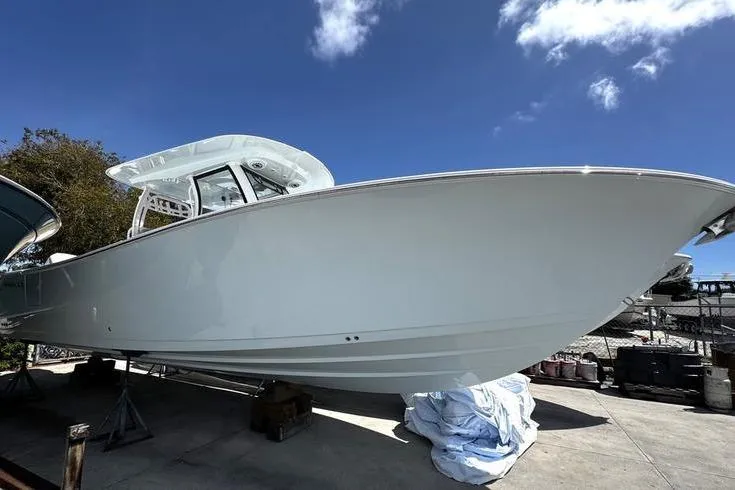 The Image of 2026 Sportsman Heritage 321 Center Console boat on display under clear blue sky. - 0