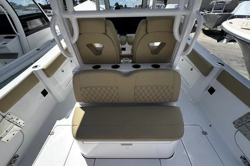 Slide: The Image of 2026 Sportsman Heritage 321 Center Console boat interior with beige seating and white table. - 10
