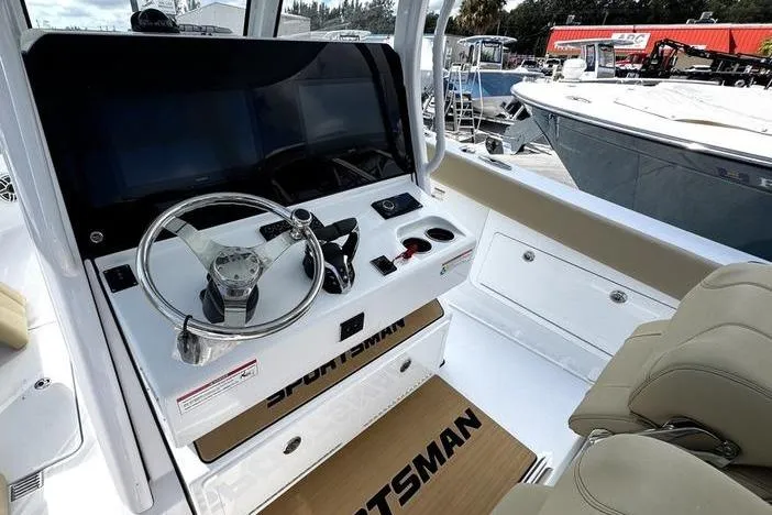 Slide: The Image of 2026 Sportsman Heritage 321 Center Console boat interior with steering wheel and controls. - 24