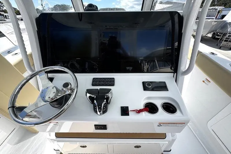 Slide: The Image of 2026 Sportsman Heritage 321 Center Console interior with beige seating and storage compartment. - 32