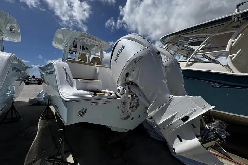 Slide: The Image of 2026 Sportsman Heritage 321 Center Console boat with Yamaha engine, docked under a cloudy sky. - 39