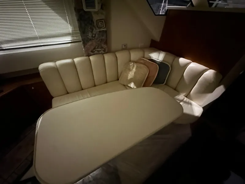 Slide: The Image of Interior of a 1998 Silverton 351 Sedan with beige sofa and table. - 21