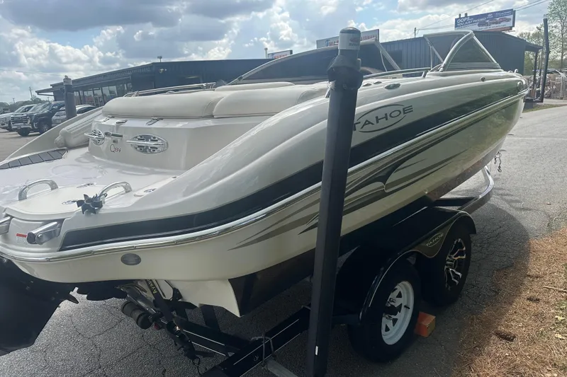 Slide: The Image of 2006 Tahoe Q8i boat on trailer under cloudy sky at dealership. - 10