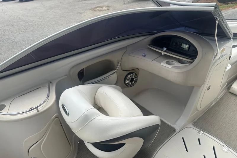 Slide: The Image of 2006 Tahoe Q8i boat interior with steering console, white seating, and cup holders. - 6