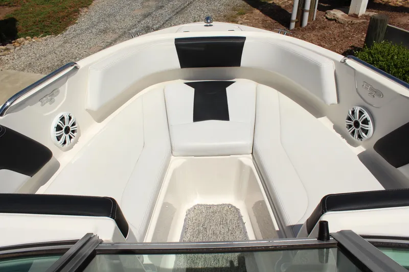 Slide: The Image of 2016 Chaparral 21 H2O Sport boat interior with white seating and speakers. - 16