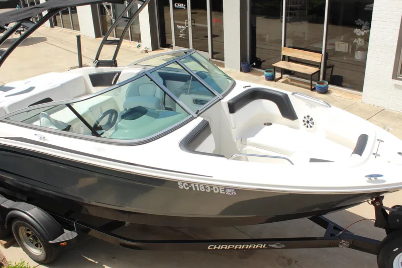 Slide: The Image of 2016 Chaparral 21 H2O Sport boat on trailer, parked outside a building. - 7