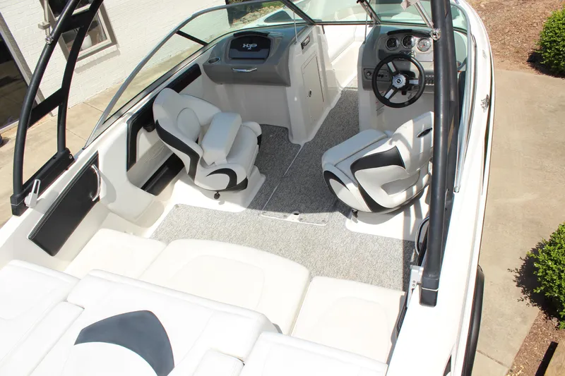 Slide: The Image of 2016 Chaparral 21 H2O Sport boat interior with white seating and steering wheel. - 8