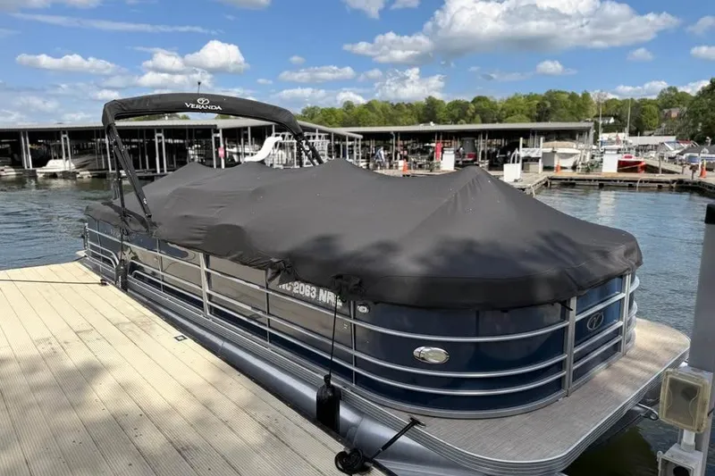 Slide: The Image of 2018 Veranda VR25RC pontoon boat docked with cover, under a clear blue sky. - 3