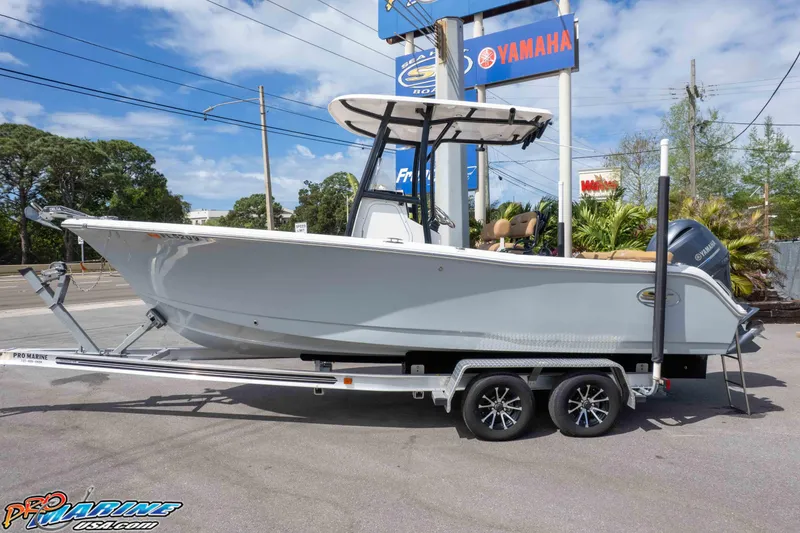 The Image of 2023 Sea Hunt Ultra 229 boat on trailer, displayed outdoors near Yamaha sign. - 0