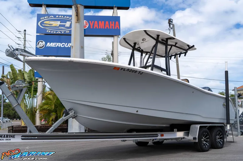 Slide: The Image of 2023 Sea Hunt Ultra 229 boat on trailer at dealership, featuring Yamaha and Mercury signage. - 14