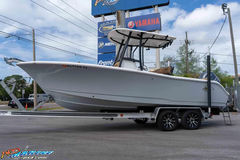 Slide: The Image of 2023 Sea Hunt Ultra 229 boat on trailer at dealership, featuring Yamaha signage. - 15