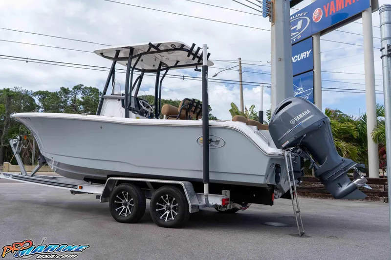 Slide: The Image of 2023 Sea Hunt Ultra 229 boat on trailer with Yamaha outboard motor, parked outdoors. - 17