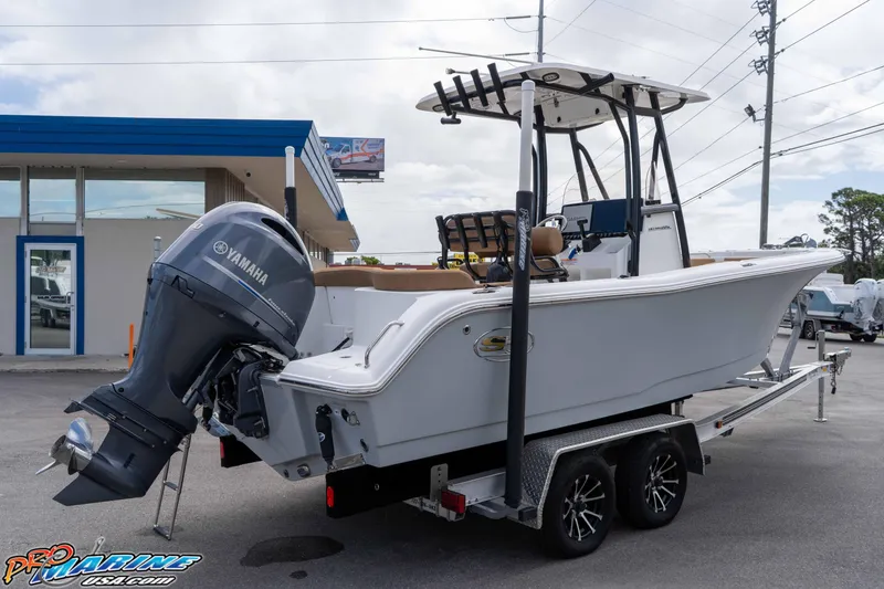 Slide: The Image of 2023 Sea Hunt Ultra 229 boat on trailer with Yamaha outboard motor, parked outdoors. - 18