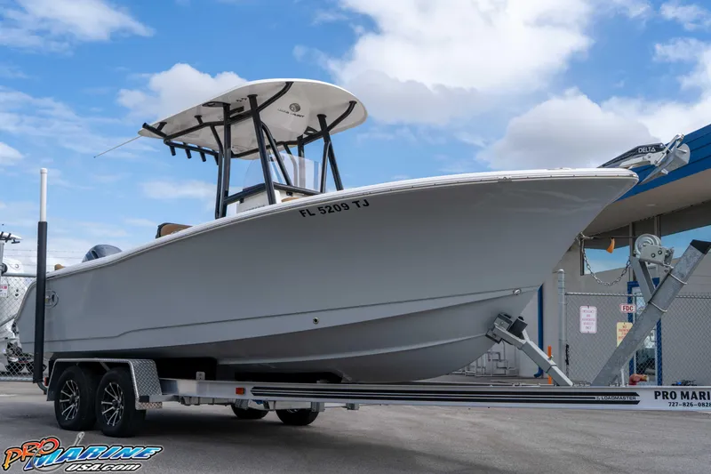 Slide: The Image of 2023 Sea Hunt Ultra 229 boat on trailer, parked outdoors under blue sky. - 20