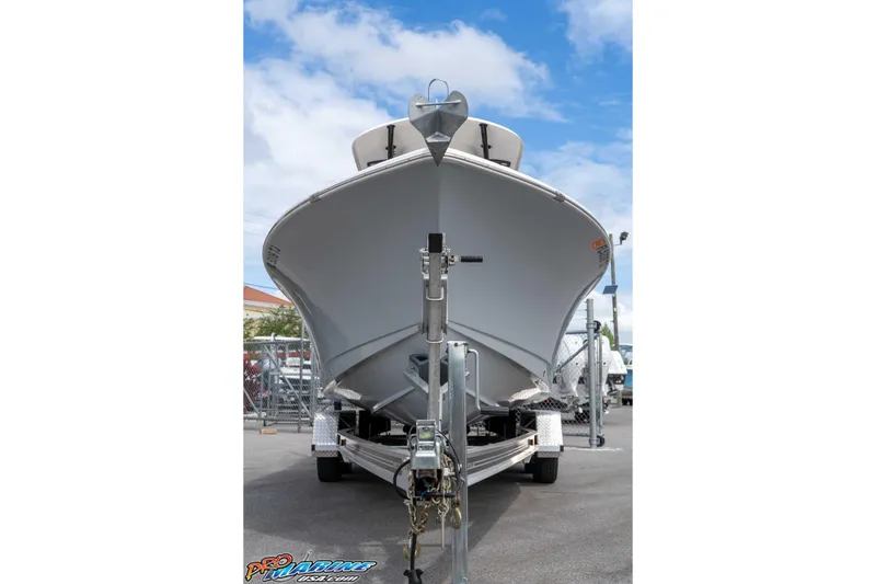 Slide: The Image of 2023 Sea Hunt Ultra 229 boat on trailer, viewed from the front under a blue sky. - 22