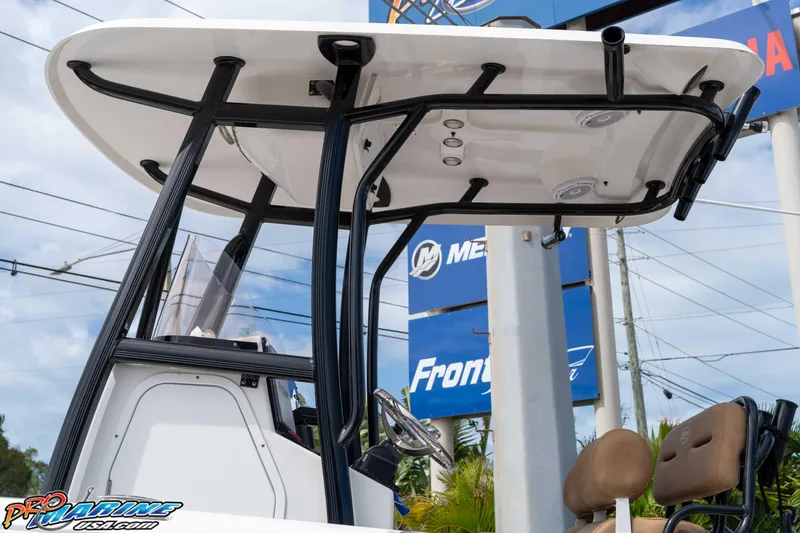 Slide: The Image of 2023 Sea Hunt Ultra 229 boat with T-top and seating, displayed outdoors. - 24