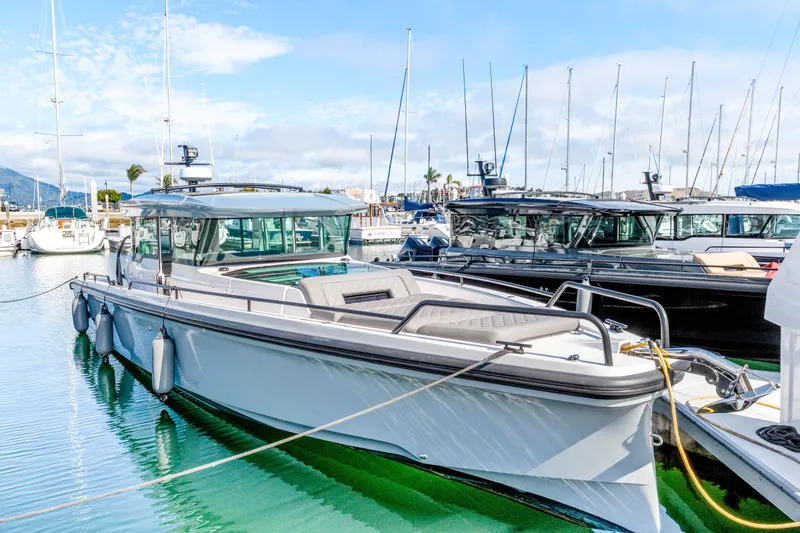 The Image of 2021 Axopar 37 XC Cross Cabin boat docked in a marina under a clear sky. - 0