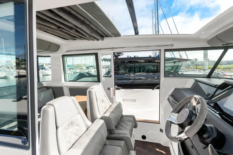 Slide: The Image of Interior view of 2021 Axopar 37 XC Cross Cabin, featuring modern seating and steering wheel. - 12