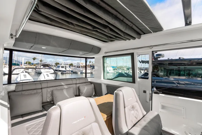 Slide: The Image of Interior of 2021 Axopar 37 XC Cross Cabin, featuring luxurious seating and marina view. - 15