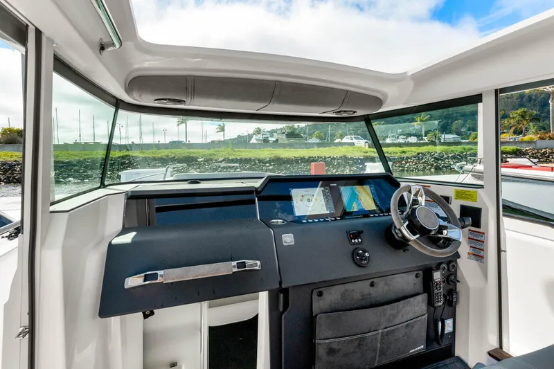 Slide: The Image of 2021 Axopar 37 XC Cross Cabin helm with modern navigation displays and steering wheel. - 17