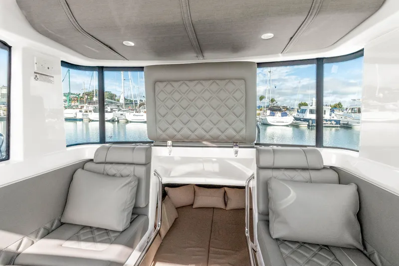 Slide: The Image of Interior of 2021 Axopar 37 XC Cross Cabin with luxurious seating and marina view. - 18