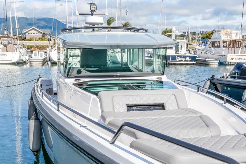 Slide: The Image of 2021 Axopar 37 XC Cross Cabin boat docked in a marina. - 2