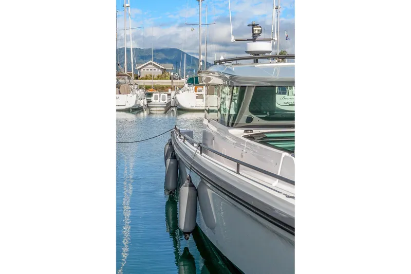 Slide: The Image of 2021 Axopar 37 XC Cross Cabin docked in a marina with clear blue water. - 32