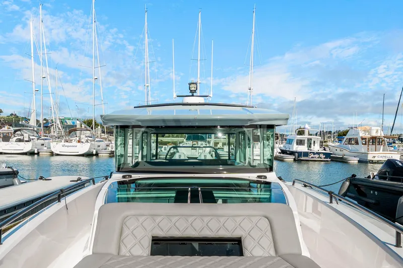 Slide: The Image of 2021 Axopar 37 XC Cross Cabin boat docked in a marina with sailboats. - 35