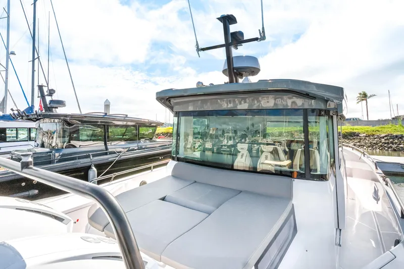 Slide: The Image of 2021 Axopar 37 XC Cross Cabin boat docked in a marina under a clear sky. - 4
