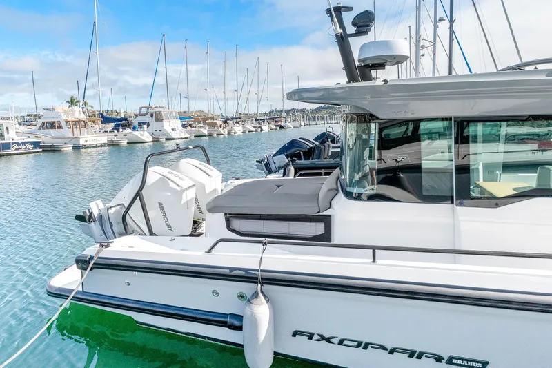 Slide: The Image of 2021 Axopar 37 XC Cross Cabin docked in a marina with other boats. - 8